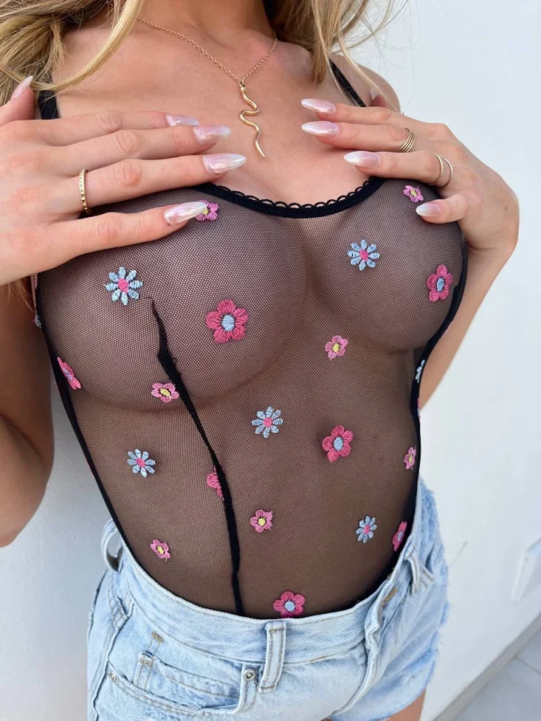 Katy Hollick @katyhollick foto van het OnlyFans-model in een zwart doorzichtig top die haar grote borsten blootstelt