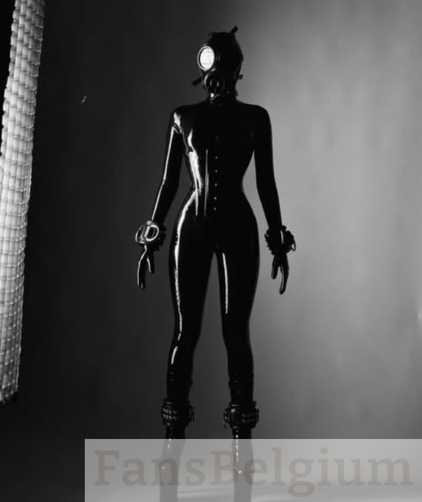 Lizanne Ligatio @lizanne_l OnlyFans modelfoto, staand in een zwarte sexy latex catsuit en een masker