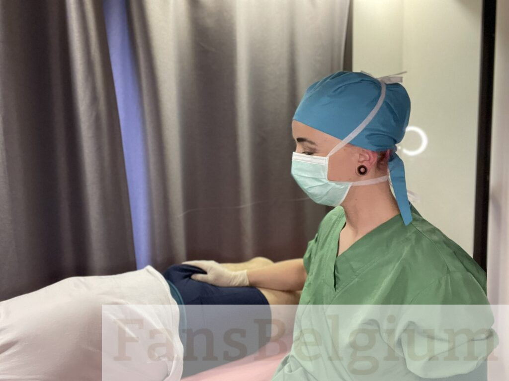 Miss Nena @nenabe OnlyFans model foto in haar kliniek met de piemel van een man in haar hand