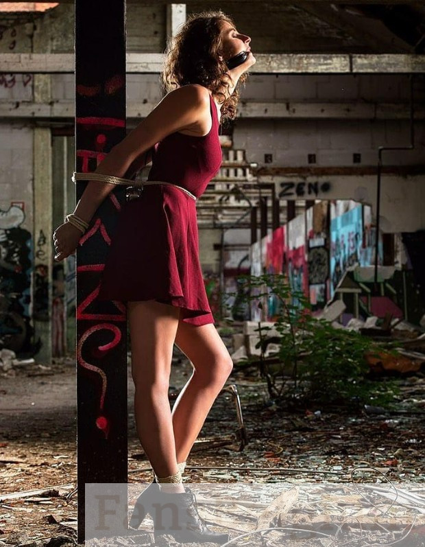 Miryam Artistic @miryamartistic OnlyFans model afbeelding vastgebonden op hout in zwart jurk