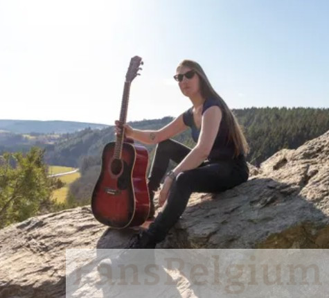 Elise Nauws @elise_nauws OnlyFans model foto op de berg in zwarte kleren terwijl ze een gitaar vasthoudt